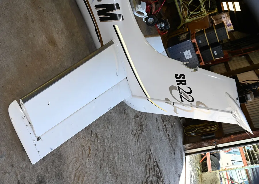 Close-up of the Cirrus SR22's damaged tail section and empennage after the tree-suspended descent and ground impact
